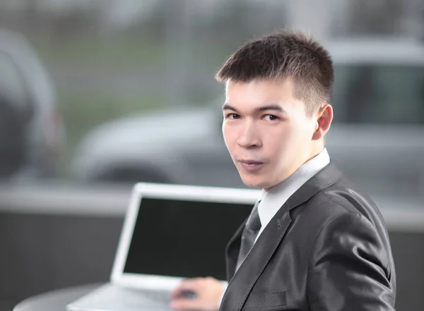 Po stronie view.young biznesmen siedząc przy biurku w biurze — Zdjęcie stockowe