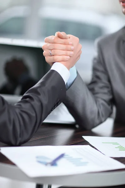 Nahaufnahme. Zwei Geschäftsleute liefern sich an einem Schreibtisch ein Armdrücken — Stockfoto