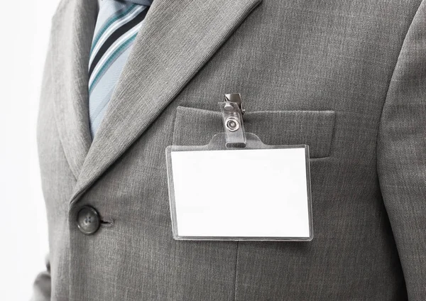 Λευκό κενό όνομα ετικέτα που επισυνάπτεται στο στήθος ενός επιχειρηματία . — Φωτογραφία Αρχείου