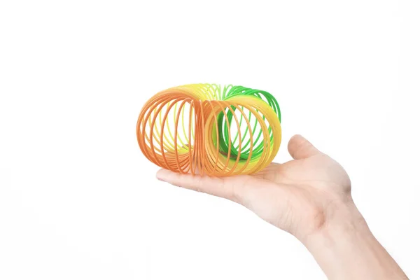 Hände streckten Regenbogenspirale. Spielzeug aus der Kindheit. — Stockfoto