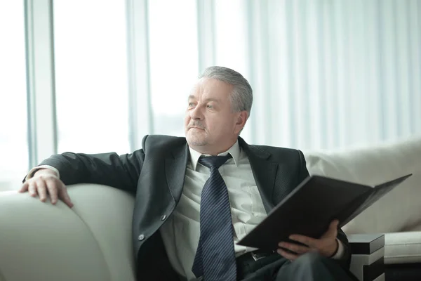 Boss with clipboard sitting on the office couch.business concept — Stock Photo, Image