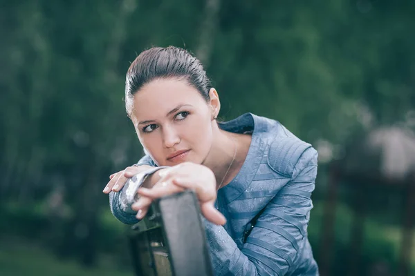 Attractive young woman sitting on a Park bench — Stock Photo, Image