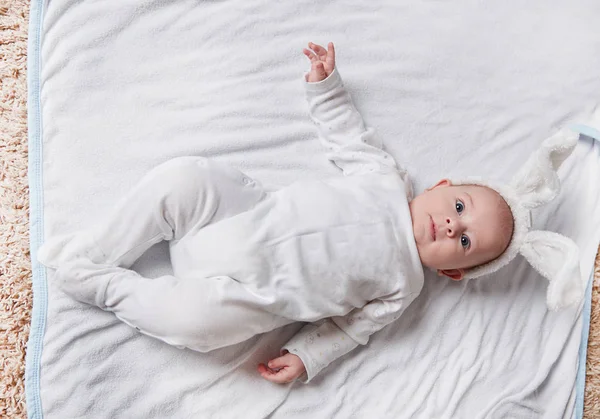 Schattig glimlachen baby liggend op het bed. — Stockfoto