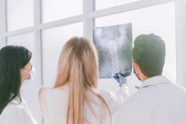 Dikiz aynası. Bir grup cerrah röntgeni tartışıyor. — Stok fotoğraf