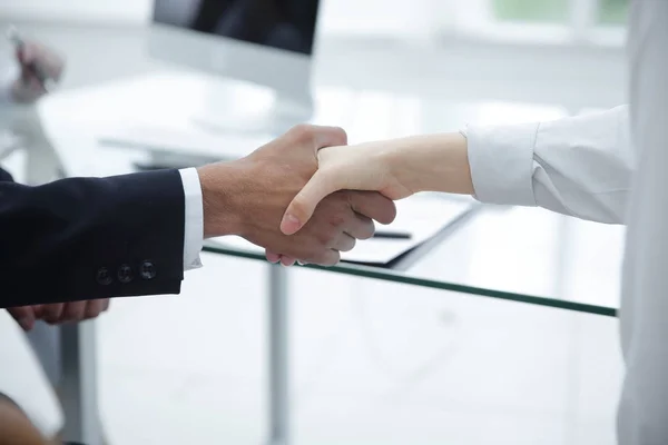 Closeup.handshake de parceiros de negócios no fundo do desktop — Fotografia de Stock