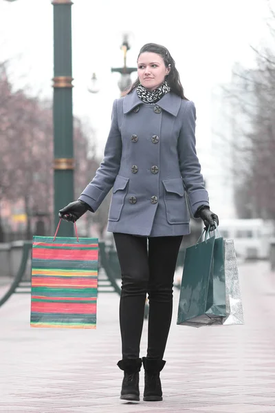 Mujer joven con bolsas de compras caminando por la calle —  Fotos de Stock