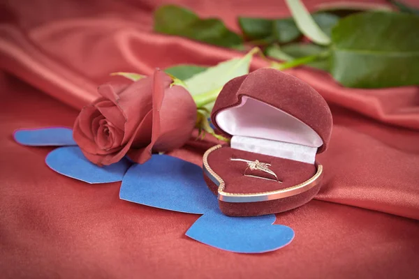 Anel de diamante e rosa no fundo vermelho brilhante — Fotografia de Stock