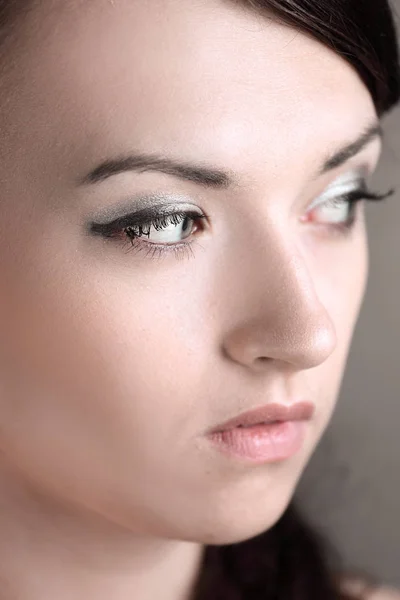 Primer plano. una joven con maquillaje diario mira hacia arriba — Foto de Stock