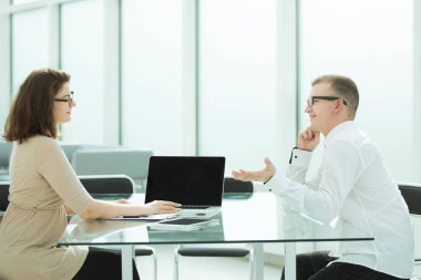 iki çalışanı office masada oturan bir şey görüşüyorlar