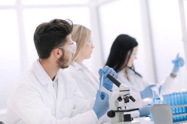 Laboratuvar masasında oturan bir grup genç biyolog.