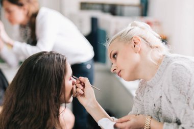 profesyonel makyöz makyaj için genç bir kadın yapar.