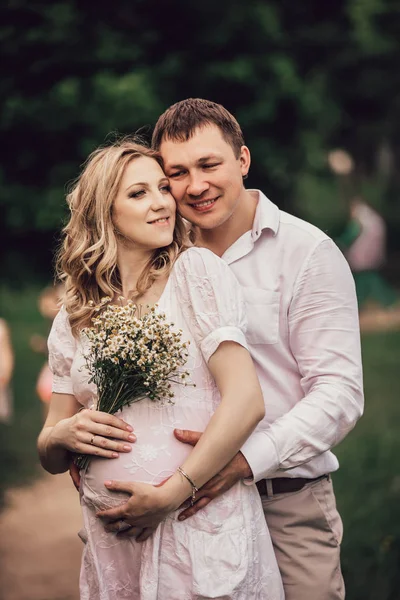 Marido abrazando esposa embarazada para un paseo en el parque —  Fotos de Stock