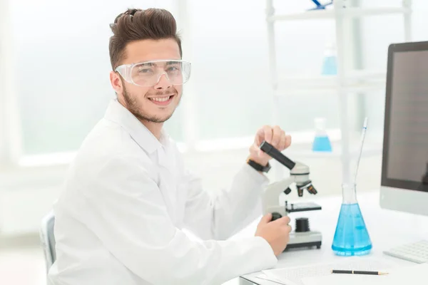 Científico moderno sentado en su escritorio en el laboratorio — Foto de Stock