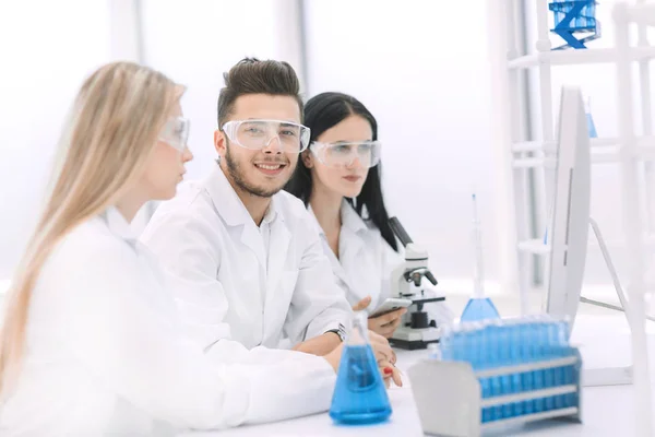 Close up.un equipo de científicos utiliza una computadora para comprobar los datos —  Fotos de Stock