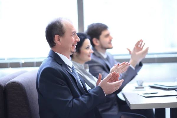 Uzavřete up.business tým tleskají reproduktor, sedící na pracovišti. — Stock fotografie