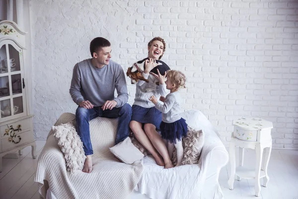 Retrato de família feliz com cão de estimação no sofá na sala de estar — Fotografia de Stock