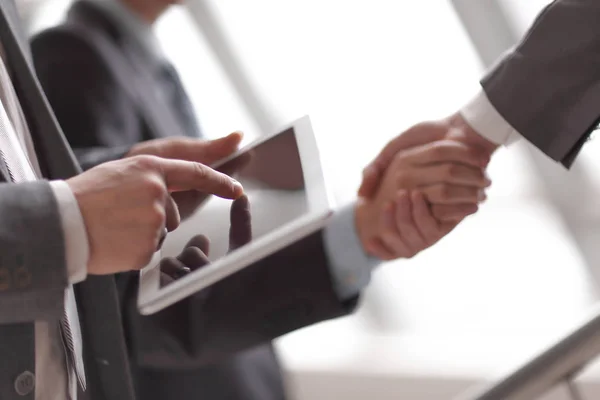 Affärsman med digital tablett i bakgrunden av handslag — Stockfoto