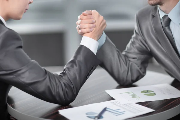 Close up. two businessmen are engaged in arm wrestling at a Desk — Stock Photo, Image