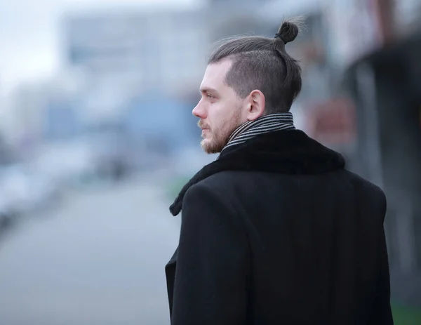 Hombre de negocios moderno en un abrigo de invierno sobre un fondo borroso . — Foto de Stock