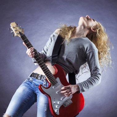 Genç ve güzel rock kızı elektro gitar çalıyor.