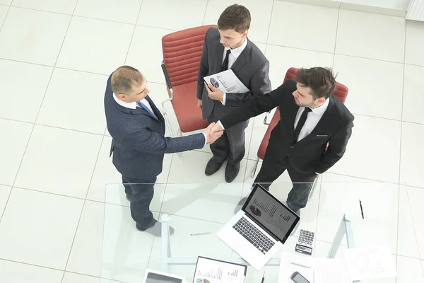 Top view.handshake των οικονομικών εταίρων πριν από την επαγγελματική συνάντηση — Φωτογραφία Αρχείου
