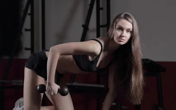 Close up. A confident woman performs an exercise with dumbbells — стоковое фото