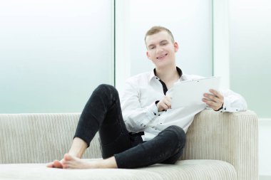 yakışıklı adam dairesinde bir dijital tablet kullanır