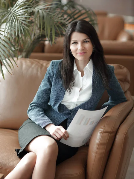 Fecha. sorridente mulher de negócios sentado no lobby do escritório — Fotografia de Stock