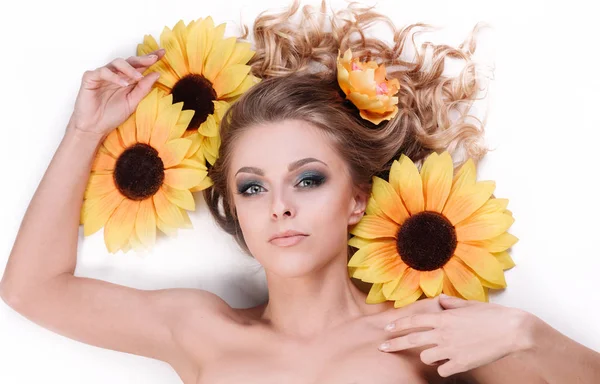 해바라기의 꽃 들 사이에서 거짓말 하는 아름 다운 젊은 여자 — 스톡 사진
