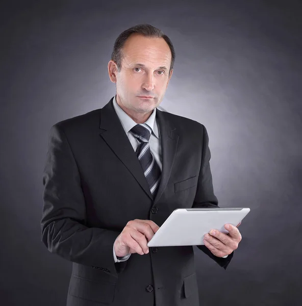 Modern businessman with a digital tablet. isolated on black background — Stock Photo, Image