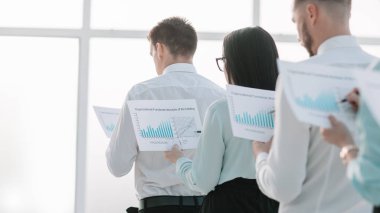 yakın çekim. finansal raporlar doğrultusunda ayakta, çalışanlarla.