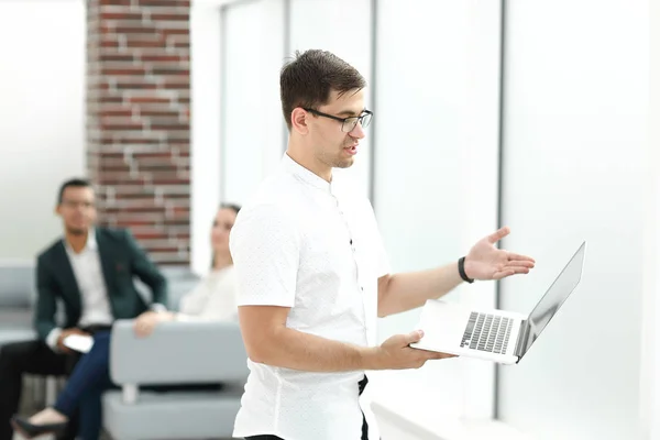 Businessman with laptop standing in business center. — Stock Photo, Image