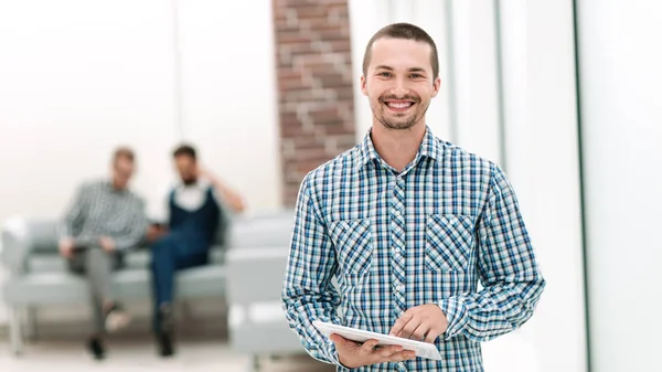 Улыбающийся мужчина с цифровым планшетом, стоящим в офисе . — стоковое фото