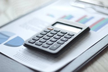 Kapat. Masaüstünde kalem ve hesap makinesinin bulanık görüntüsü