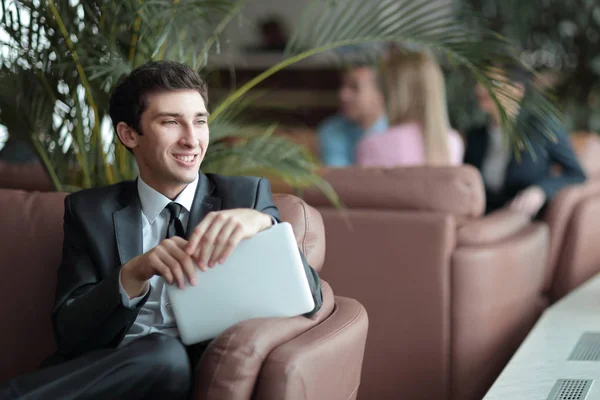 Primo piano di un giovane imprenditore che utilizza un tablet digitale seduto nella hall della Banca — Foto Stock