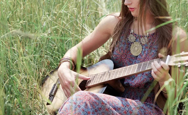 young hippie woman with guitar performs a song