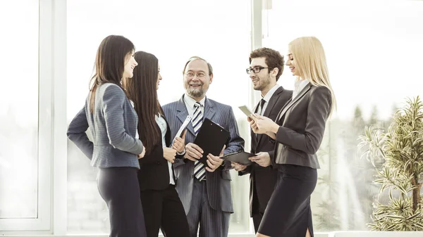 Professional business team with documents standing in the centre of the spacious office — Stock Photo, Image