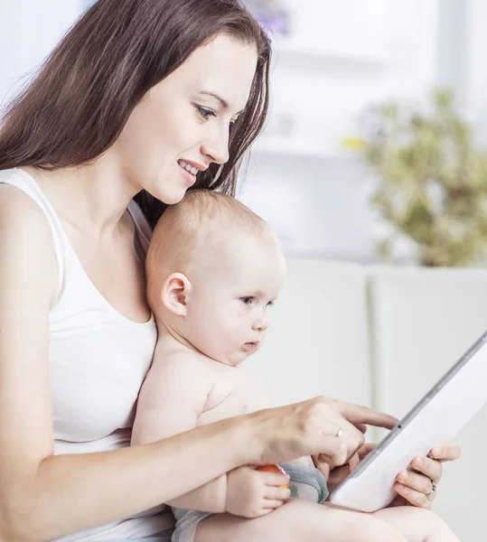 Glückliche Mutter zeigt ihrem einjährigen Baby Bilder auf digitalem Tablet — Stockfoto