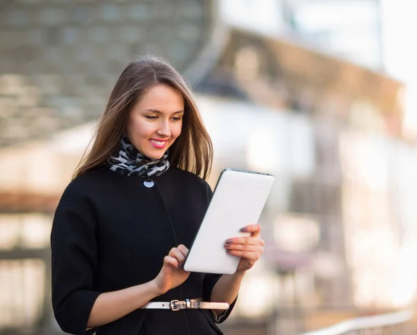 Bir ofis binası yakınındaki bir dijital tablet üzerinde çalışan başarılı iş kadını — Stok fotoğraf