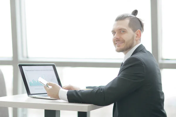 Casual businessman working with mobile and laptop in modern office — Stock Photo, Image