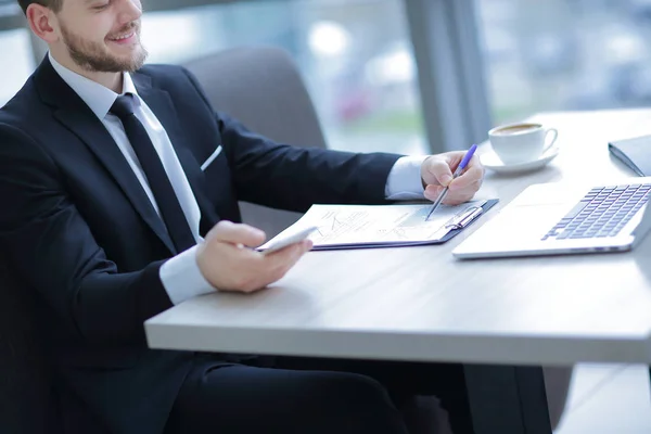 Closeup.businessman verificando ficha financeira, sentado na mesa — Fotografia de Stock