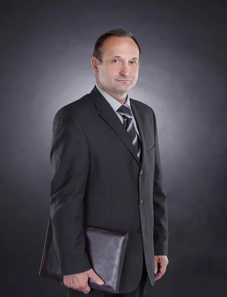 Handsome businessman with a leather folder .isolated on black — Stock Photo, Image