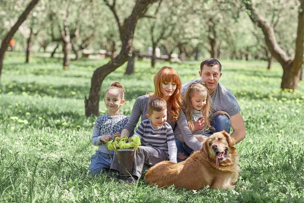 Família feliz em um piquenique em um dia de primavera — Fotografia de Stock