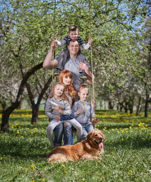 Retrato de una familia feliz en un columpio en su jardín —  Fotos de Stock