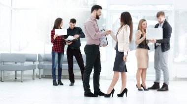 Toplantı salonunda iş ortakları el sıkışıyor.