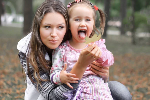Maminka a malá dcerka v parku na podzimní den — Stock fotografie