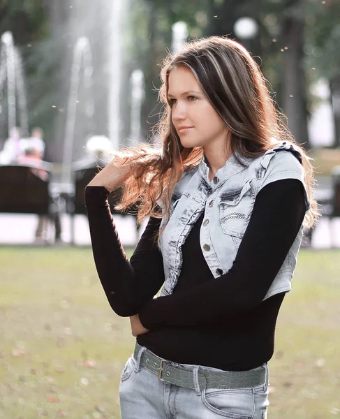 Elegante giovane donna su uno sfondo di parco della città — Foto Stock