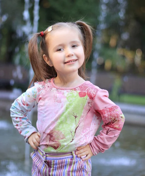 Portret van gelukkig klein meisje in de buurt van fontein in stad Park — Stockfoto
