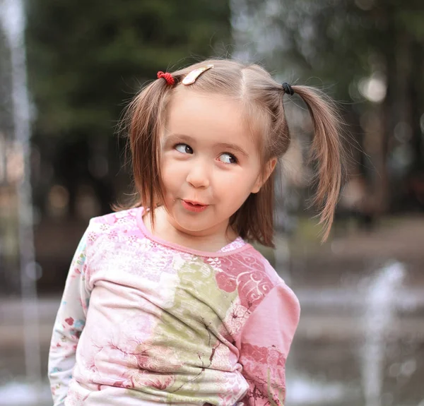 Gadis kecil yang cantik di latar belakang air mancur kota — Stok Foto