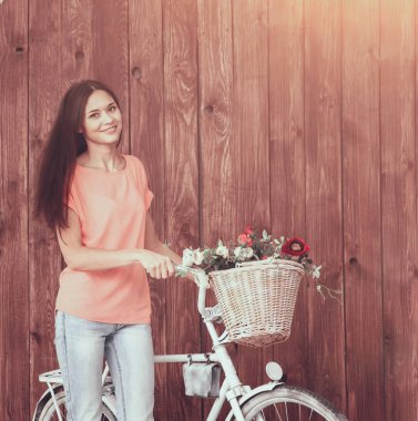 Kamera seyir onu bisiklet ve kır çiçekleri sepeti ile romantik genç bir kadın. Yaz.